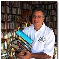 John Salvatore Guagliardo with an armful of books in a library
